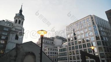 在伦敦市中心，在<strong>蓝色</strong>的<strong>夜空下</strong>，现代化的玻璃摩天大楼附近，亮起黄色的路灯